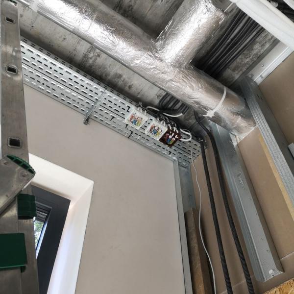 instalacja elektryczna ułożona w metalowych kanałach w suficie podwieszanym